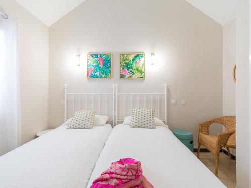 2 Betten in einem kleinen Schlafzimmer mit 2 Stühlen in der Unterkunft Bungalow Maspalomas Leticia in Maspalomas