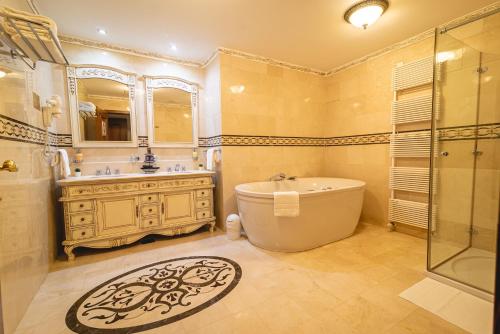 y baño con bañera, lavamanos y ducha. en Casino & Hotel ADMIRAL Skofije, en Zgornje Škofije