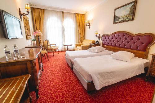 a hotel room with two beds and a red carpet at Casino & Hotel ADMIRAL Skofije in Zgornje Škofije