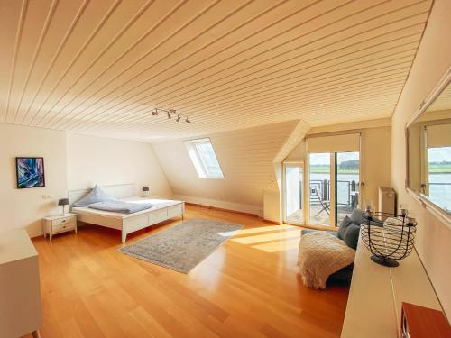 una grande camera con letto e soffitto in legno di Rheinloft 3 - Große Giebelwohnung mit Dachterrassen an der Rheinpromenade a Emmerich am Rhein