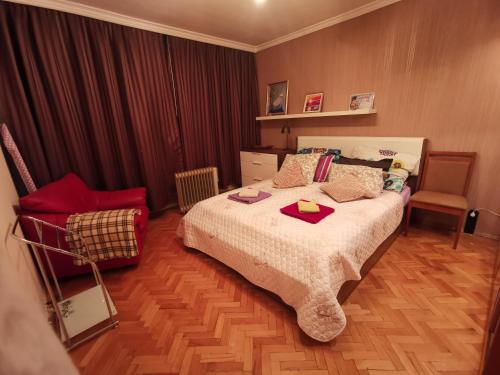 a bedroom with a large bed and a chair at Spacious quiet apartment next to Arena Armeec and Metro station GM Dimitrov in Sofia