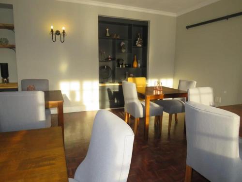 a dining room with a table and white chairs at Sani Pass Manor Guest House in Himeville
