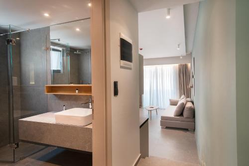 a bathroom with a sink and a shower and a tub at The Residences Kalamata in Kalamata