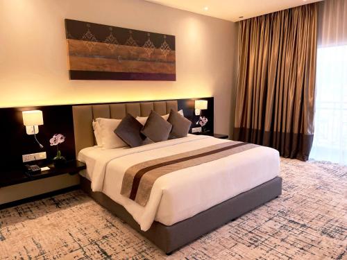 een slaapkamer met een groot bed in een kamer bij Grand Darul Makmur Hotel Kuantan in Kuantan