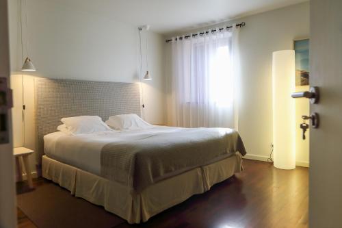 a bedroom with a large bed and a window at Casas do Soito in Seia