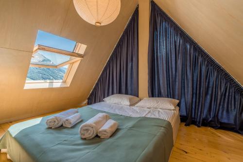 a bedroom with a bed with towels on it at Kazbegi Targmani Cottages in Kazbegi