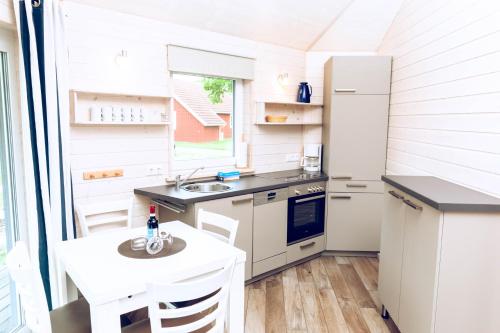 a small kitchen with a table and a refrigerator at Regenbogen Boltenhagen in Boltenhagen