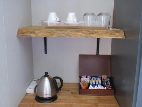 a shelf with a tea kettle on a table at Sani Pass Manor Guest House in Himeville