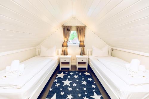 two beds in a attic room with an american flag rug at Regenbogen Boltenhagen in Boltenhagen
