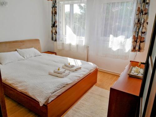 a bedroom with a bed with towels on it at Lend apartment in Miercurea-Ciuc