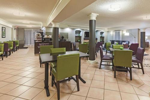a restaurant with tables and chairs in a cafeteria at Travelodge by Wyndham Houston Cy-Fair in Houston