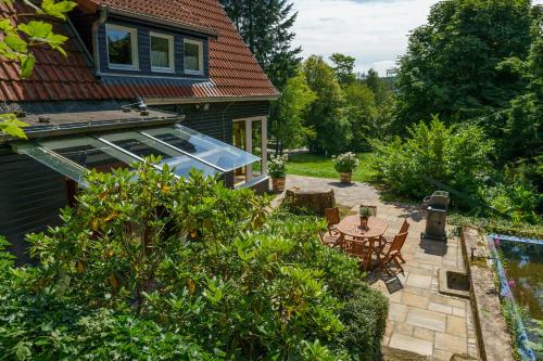 einen Hinterhof mit einer Terrasse mit einem Tisch und Stühlen in der Unterkunft Waldhäuschen am Sonnenhof in Kassel