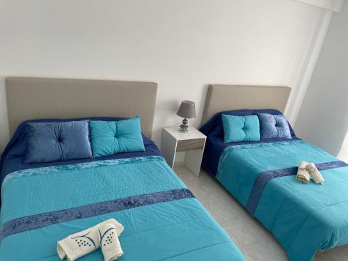 Dos camas en una habitación con almohadas azules. en Casa Marques, en Nazaré
