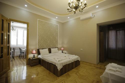 a bedroom with a bed and a chandelier at HOTEL COMFORT in Kutaisi