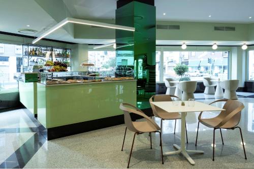 a restaurant with a table and chairs and a counter at Antares Hotel Concorde, BW Signature Collection by Best Western in Milan