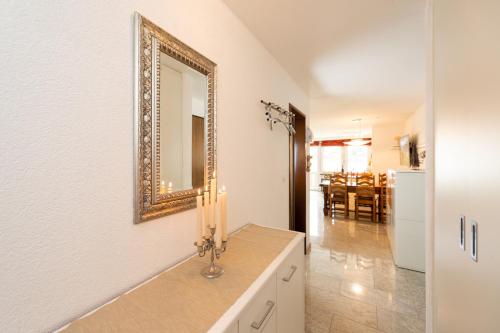La salle de bains est pourvue d'un miroir et d'un comptoir avec lavabo. dans l'établissement Apartment Castello, à Grächen