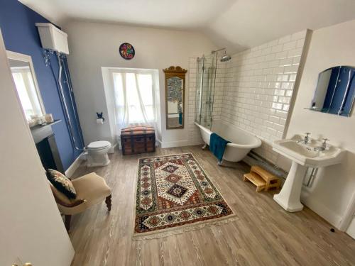 a bathroom with a tub and a sink and a toilet at Awel y Mor in Beaumaris