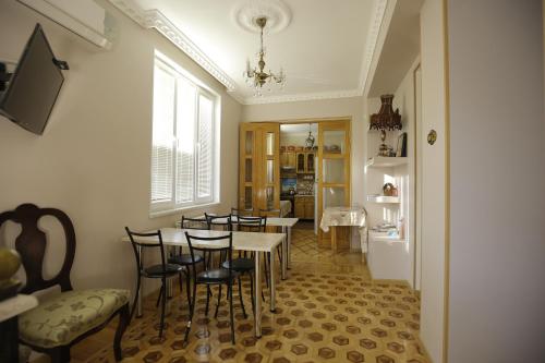 a dining room with a table and chairs and a refrigerator at HOTEL COMFORT in Kutaisi