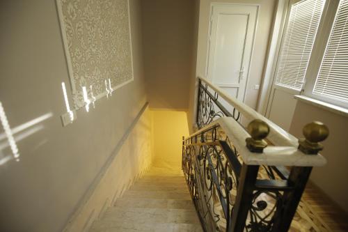 a stairway with a wrought iron railing in a room at HOTEL COMFORT in Kutaisi