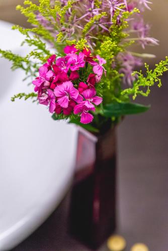 a vase filled with pink flowers on a table at Casino & Hotel ADMIRAL Ptuj in Ptuj