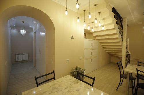 a dining room with a table and a staircase at HOTEL COMFORT in Kutaisi