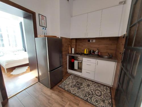 a kitchen with white cabinets and a stainless steel refrigerator at Apartment in Old Town - view of Mariacki Church in Gdańsk