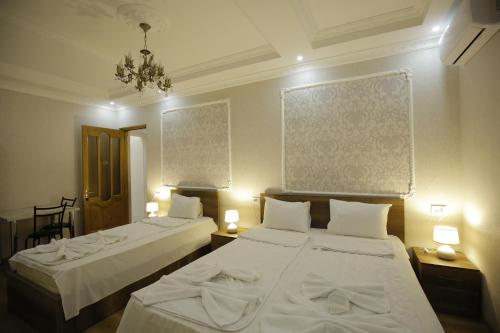 a bedroom with two beds and a chandelier at HOTEL COMFORT in Kutaisi