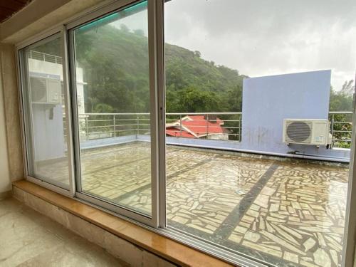 a balcony with sliding glass doors and a view at Prime Villa in Lonavala