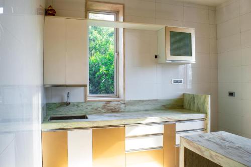 a kitchen with a sink and a window at Prime Villa in Lonavala