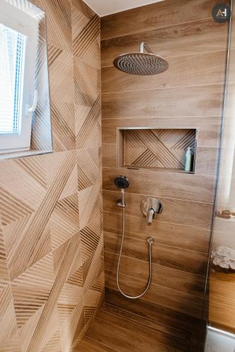 a shower in a bathroom with wooden walls at AH Nová Terasa II in Košice