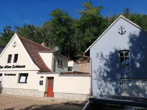 a white building with an anchor on it at Ferienhaus Zur alten Schleuse in Wettin