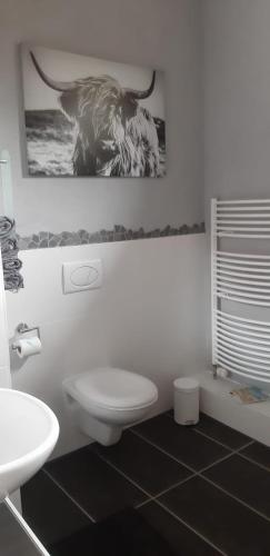 a bathroom with a toilet and a picture of an elephant at Ferienwohnung Alte Dorfschule in Witzenhausen