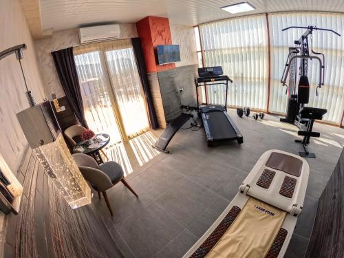 a large room with a gym with a treadmill at Hotel Story in Skopje