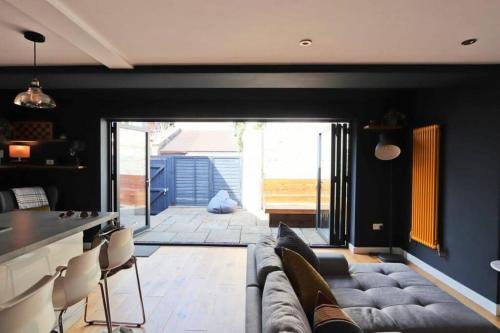 ein Wohnzimmer mit einem Sofa und einem Tisch in der Unterkunft Hotwells Modern Mews in Bristol