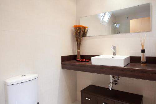 ein Badezimmer mit einem weißen Waschbecken und einem Spiegel in der Unterkunft Homenfun Barcelona Montjuic in Barcelona