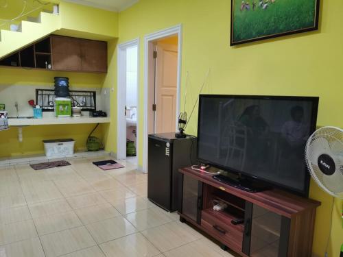 a living room with a large flat screen tv at Villa Wubao Kota Bunga 3 Kamar Harga Budget in Cinengangirang