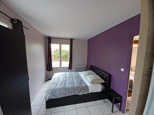 ein Schlafzimmer mit einem Bett mit einer lila Wand in der Unterkunft L'escale honfleuraise in Honfleur