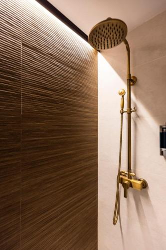 a shower with a shower head in a bathroom at Apartamentos turísticos MAJMA in Cáceres