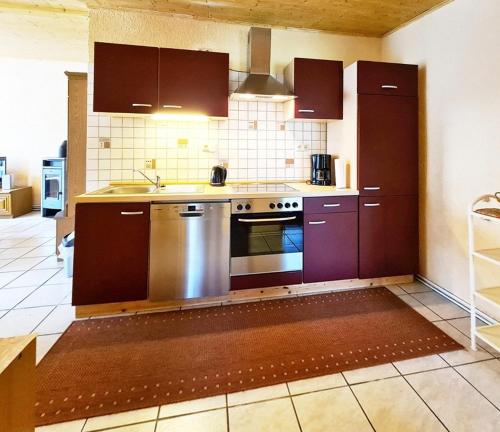 a kitchen with purple cabinets and a stainless steel oven at Apartement Rosenbusch in Klausdorf Mecklenburg Vorpommern