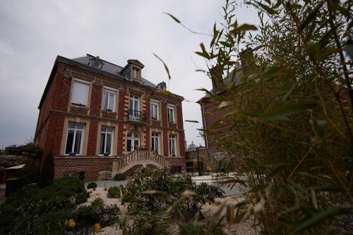 a large brick building with a balcony on the side of it at L'Antre de Gadag in Forges-les-Eaux