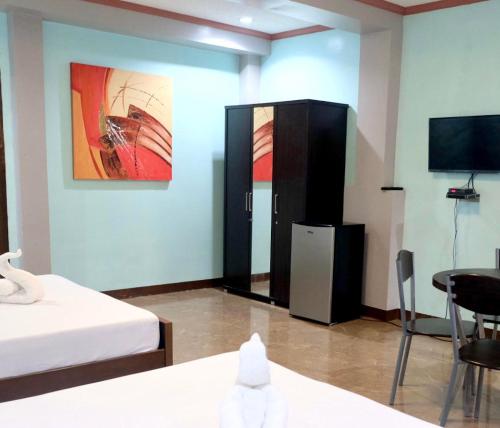 a room with two beds and a flat screen tv at Keyun's Inn- Across Cloud 9 in General Luna