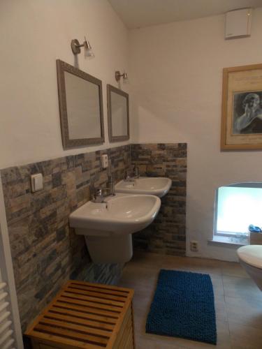 a bathroom with two sinks and a mirror at Tintaglia, betaalbaar en gastvrij in Stadskanaal