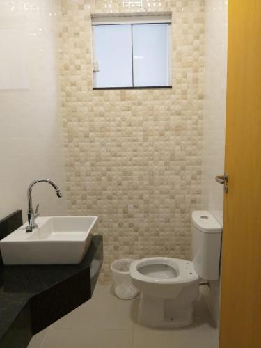 a bathroom with a sink and a toilet and a window at RESIDENCIA CIDADE VERDE 11 in Maringá