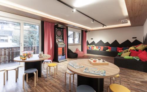 a living room with two tables and a couch at first mountain Hotel Ötztal in Längenfeld