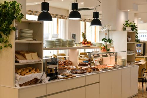 a bakery counter with a lot of food on display at Hotel Delle Mimose in Lido di Jesolo