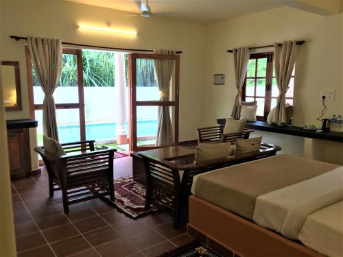 a bedroom with a bed and a table and chairs at Mandaram villas in Mararikulam