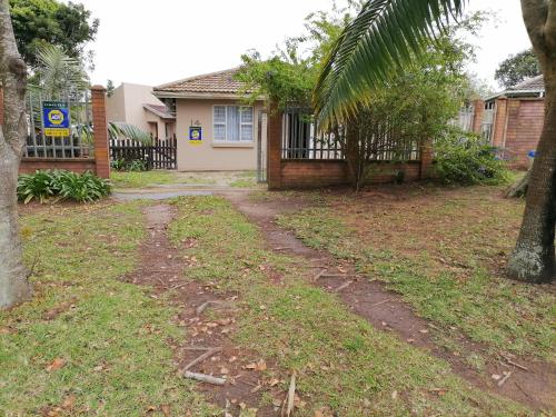 a house with a dirt road in front of a yard at eagles inn in Richards Bay