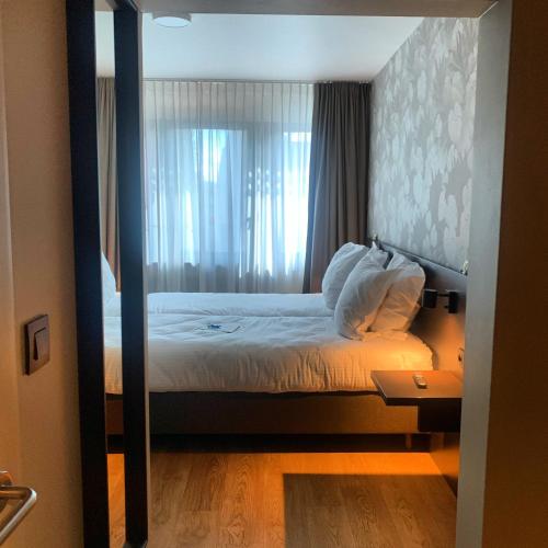 a bedroom with a bed with a large window at Bloomhotel in Lochristi