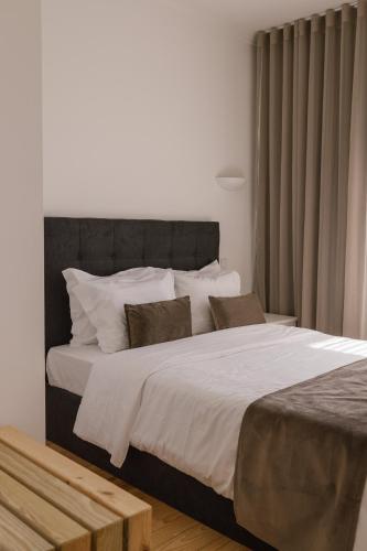a bedroom with a large bed with white sheets and pillows at Quinta do Eden in Vagos