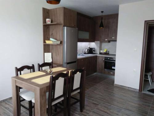 een keuken met een tafel en stoelen en een koelkast bij Nev Apart New in Velingrad